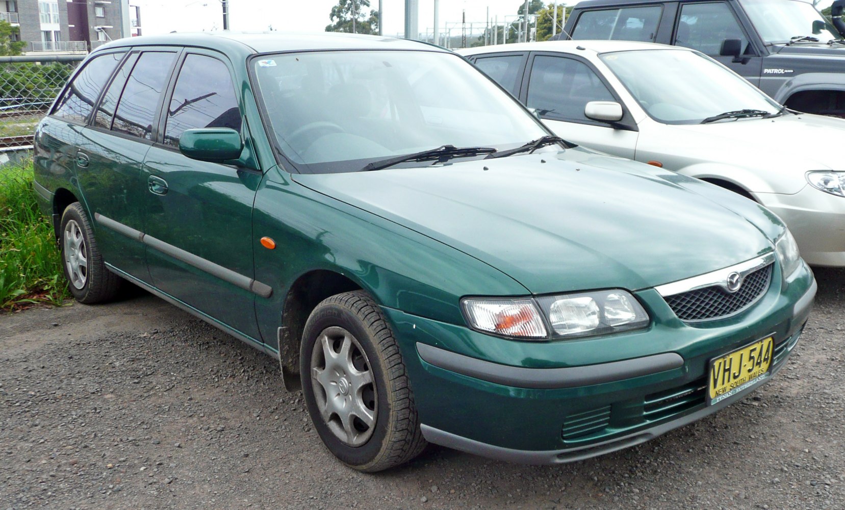Front side view of green station wagon with distinct headlights and trim.