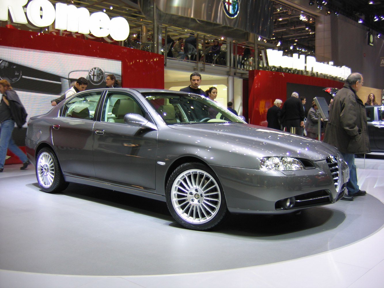 Grey sedan with multi-spoke alloy wheels and sharp headlights