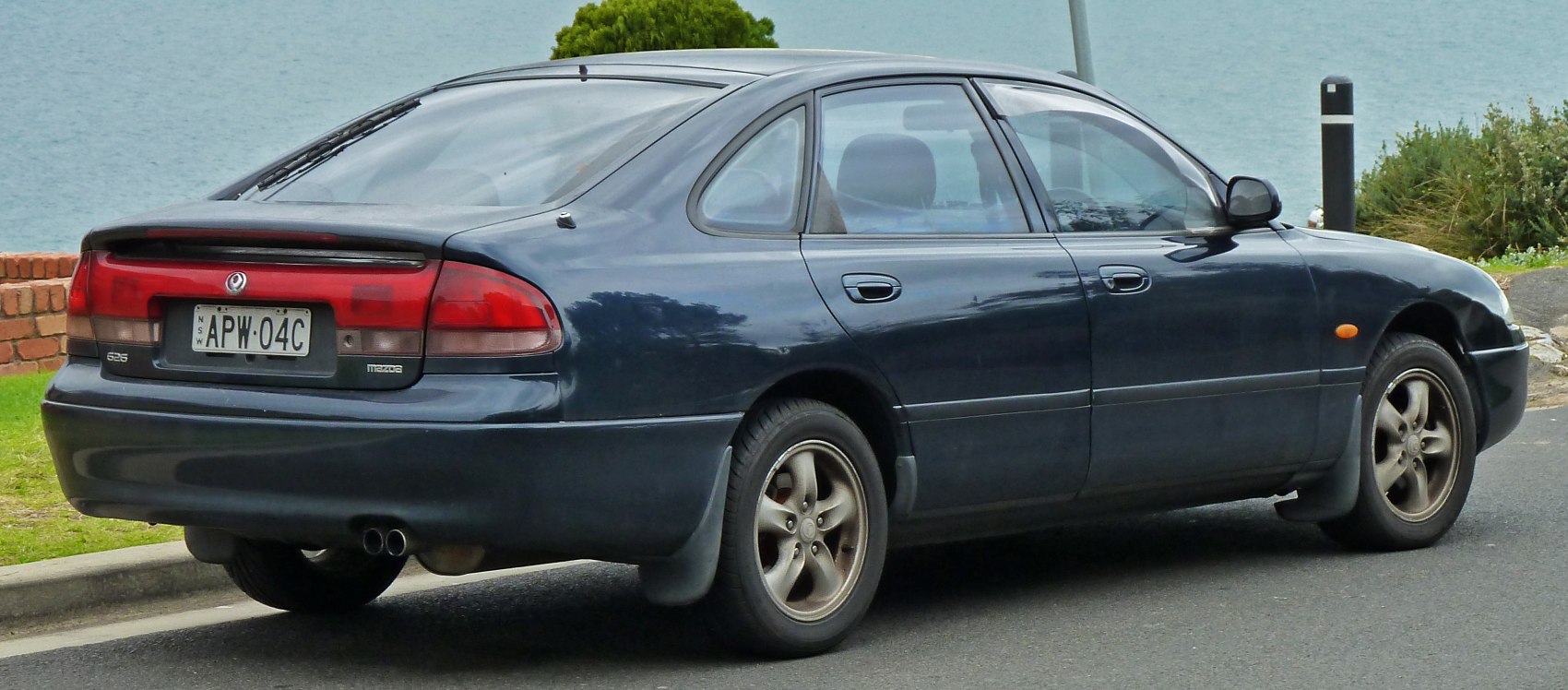 Rear and side view of a compact hatchback with dual exhaust and classic taillight design