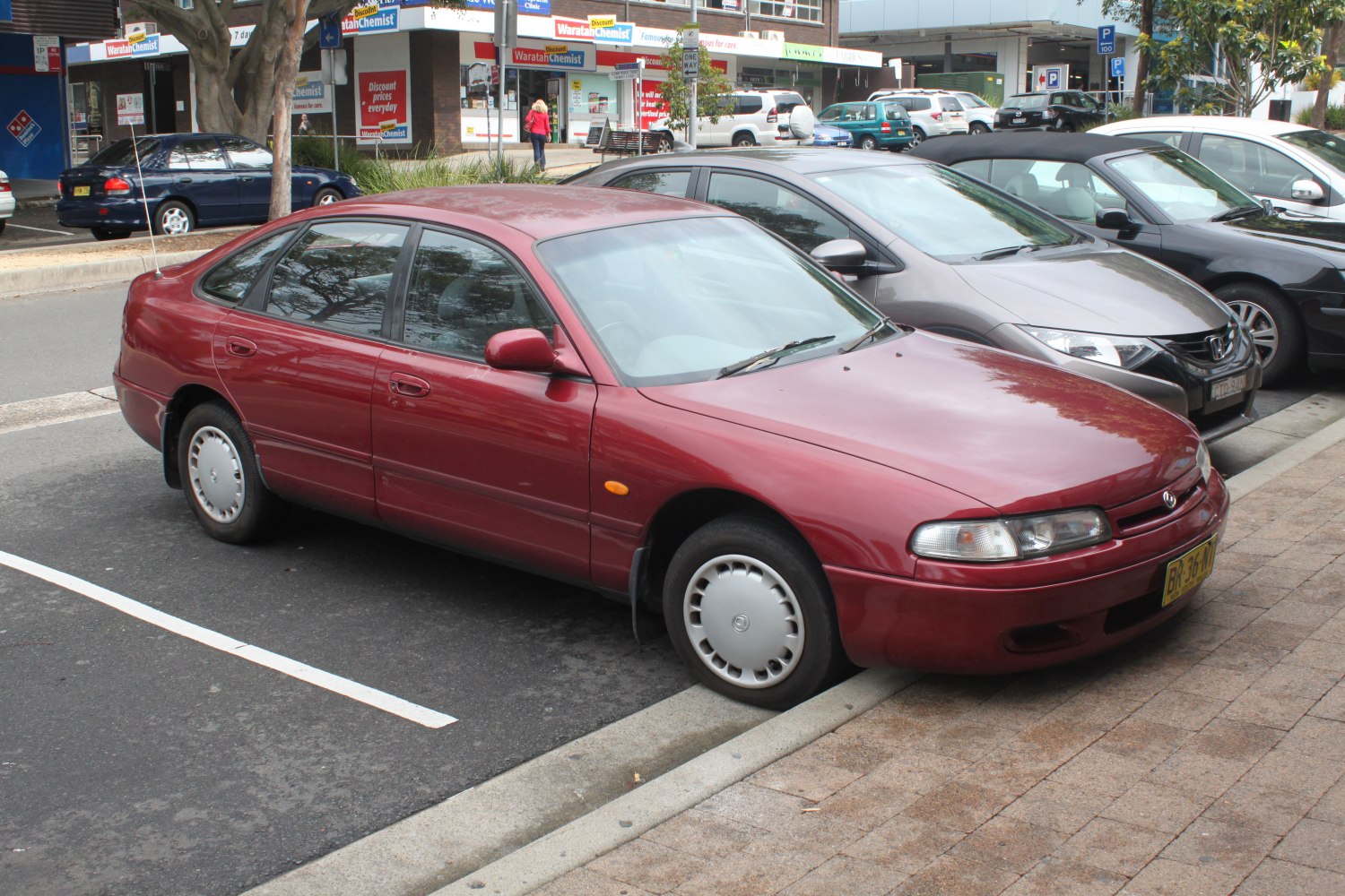 Mid-90s four-door sedan with rounded front and steel wheels with hubcaps