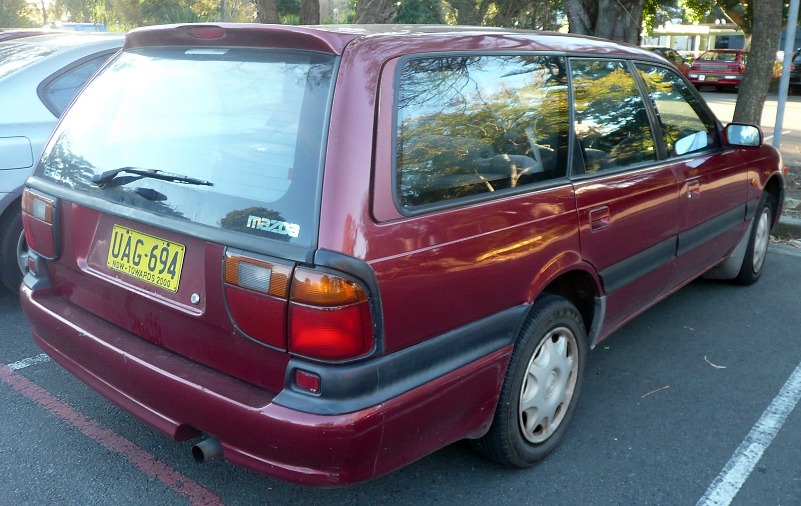 Rear-side view of a burgundy station wagon with distinctive tail lights.