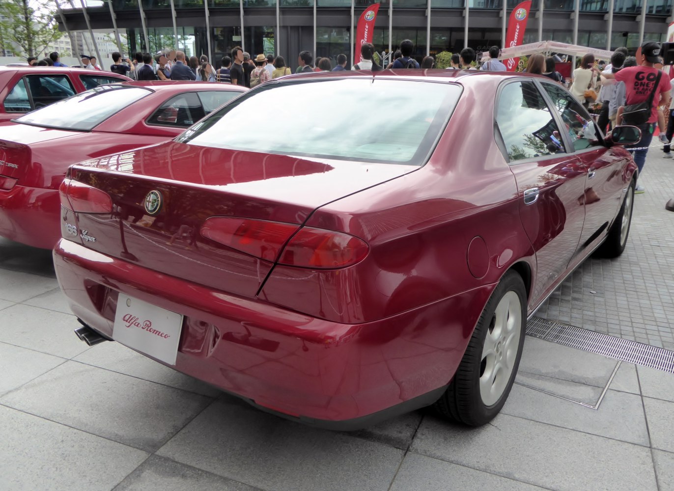 Red sedan rear and side view with distinct taillights and wheels