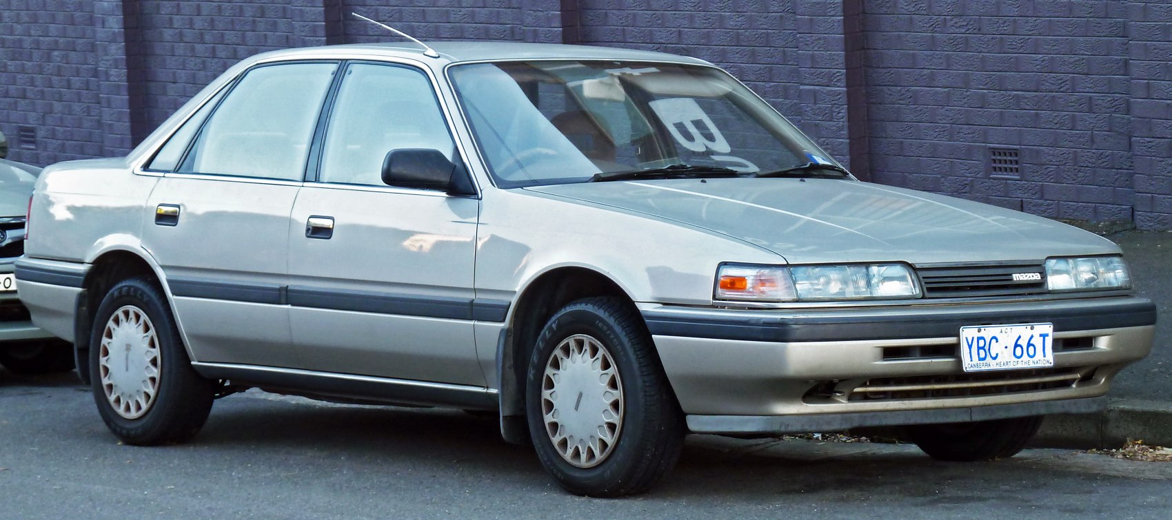Side and front view of a 1987 mid-size sedan with rectangular headlights and simple design lines