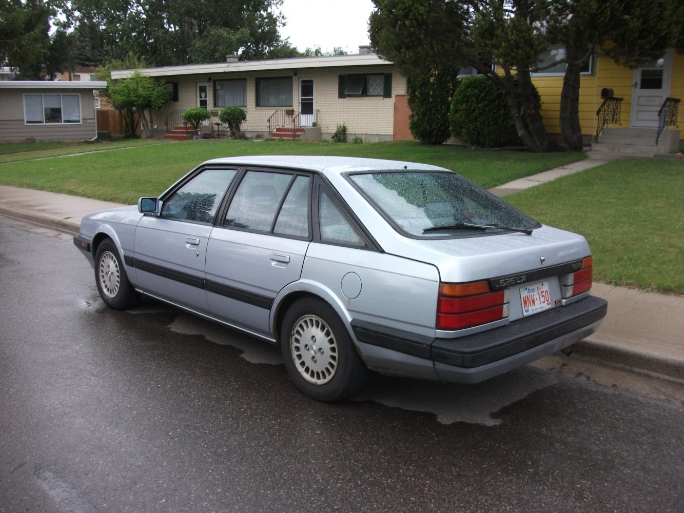 Rear and side view of vintage hatchback with angular design and rear windshield wiper.