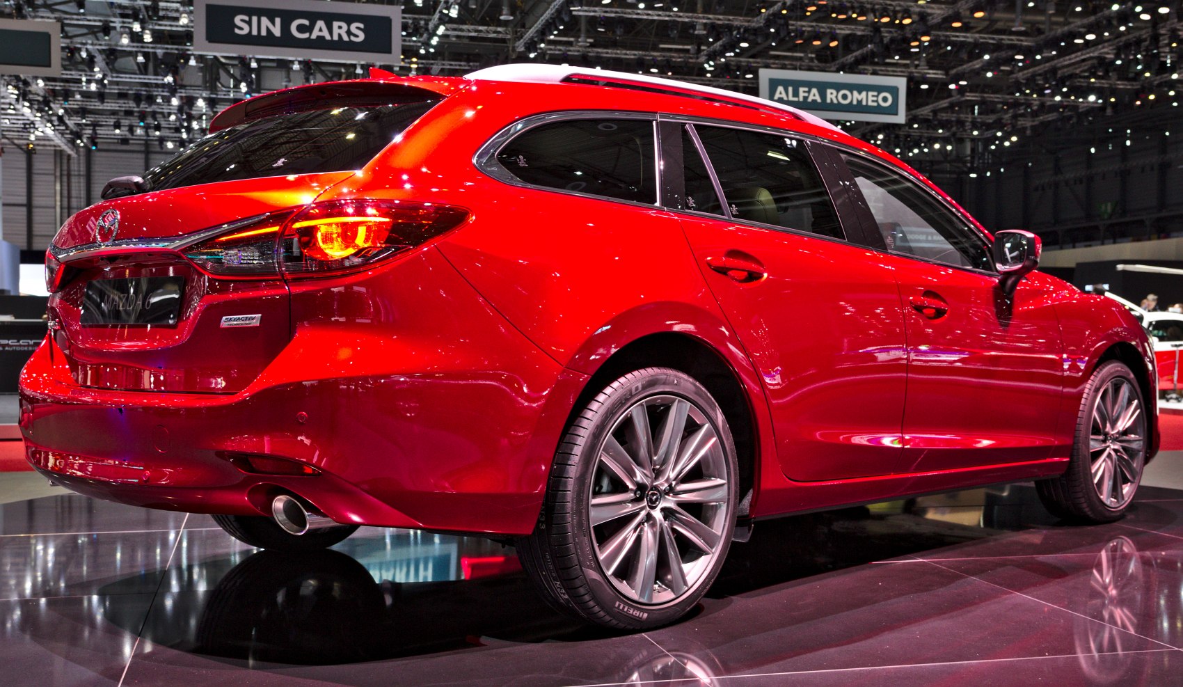 Red station wagon showing rear and side profile with alloy wheels and tail lights