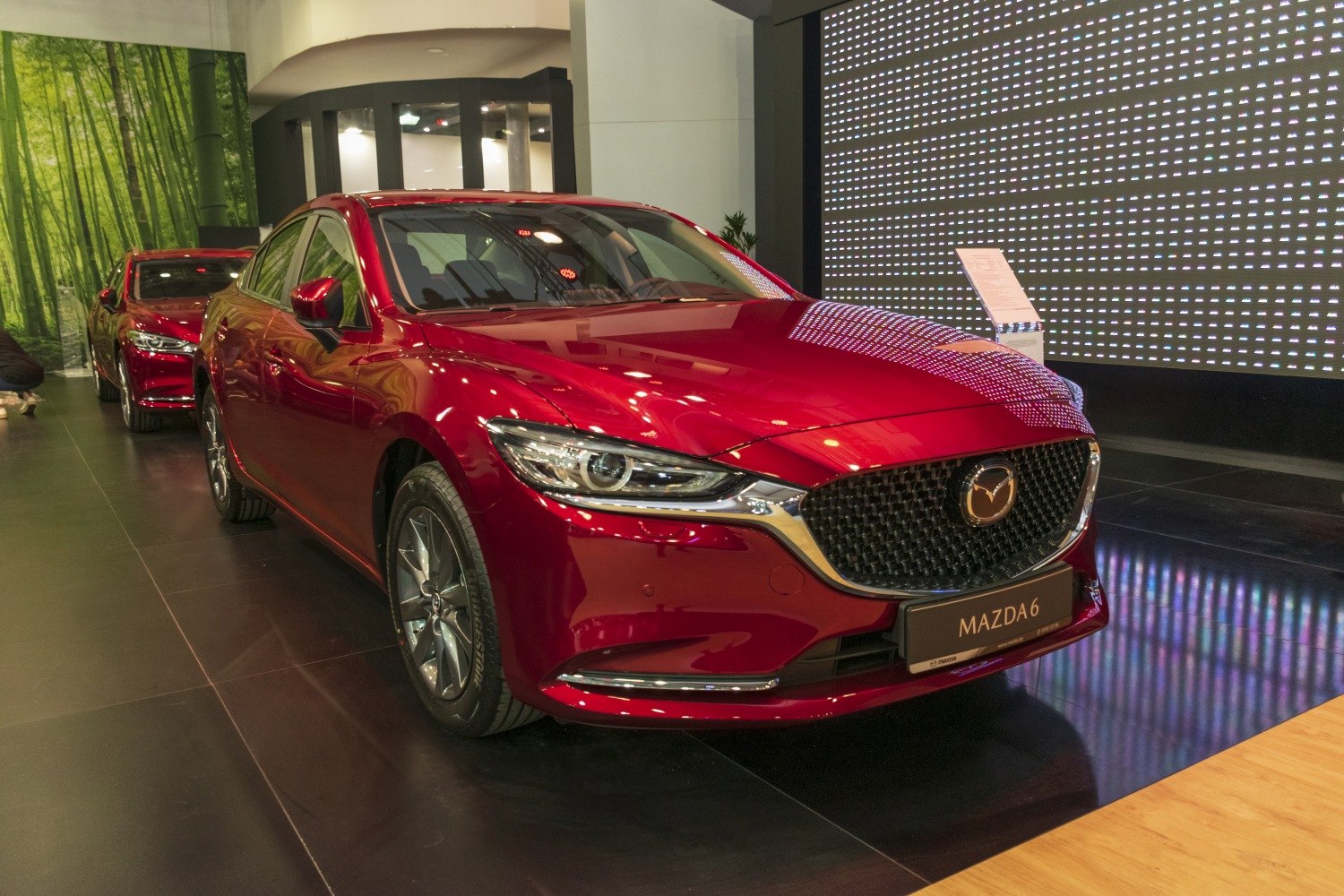 Front view of red sedan with LED headlights and mesh grille