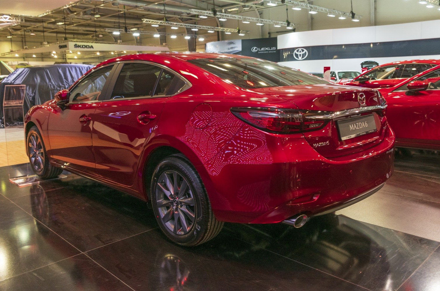 Rear side view of red sedan with sleek taillights and alloy wheels