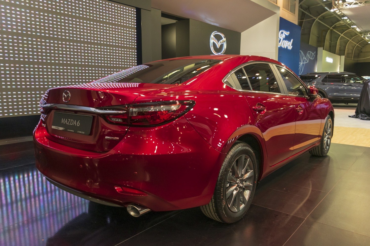 Rear view of a red sedan with sleek taillights and alloy wheels