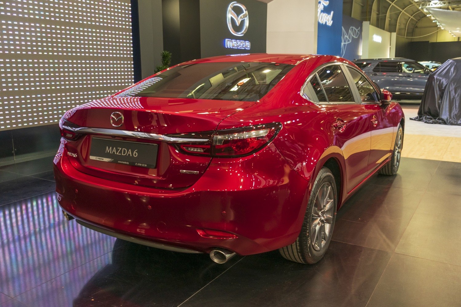 Rear view of a red sedan with chrome trim and dual exhaust