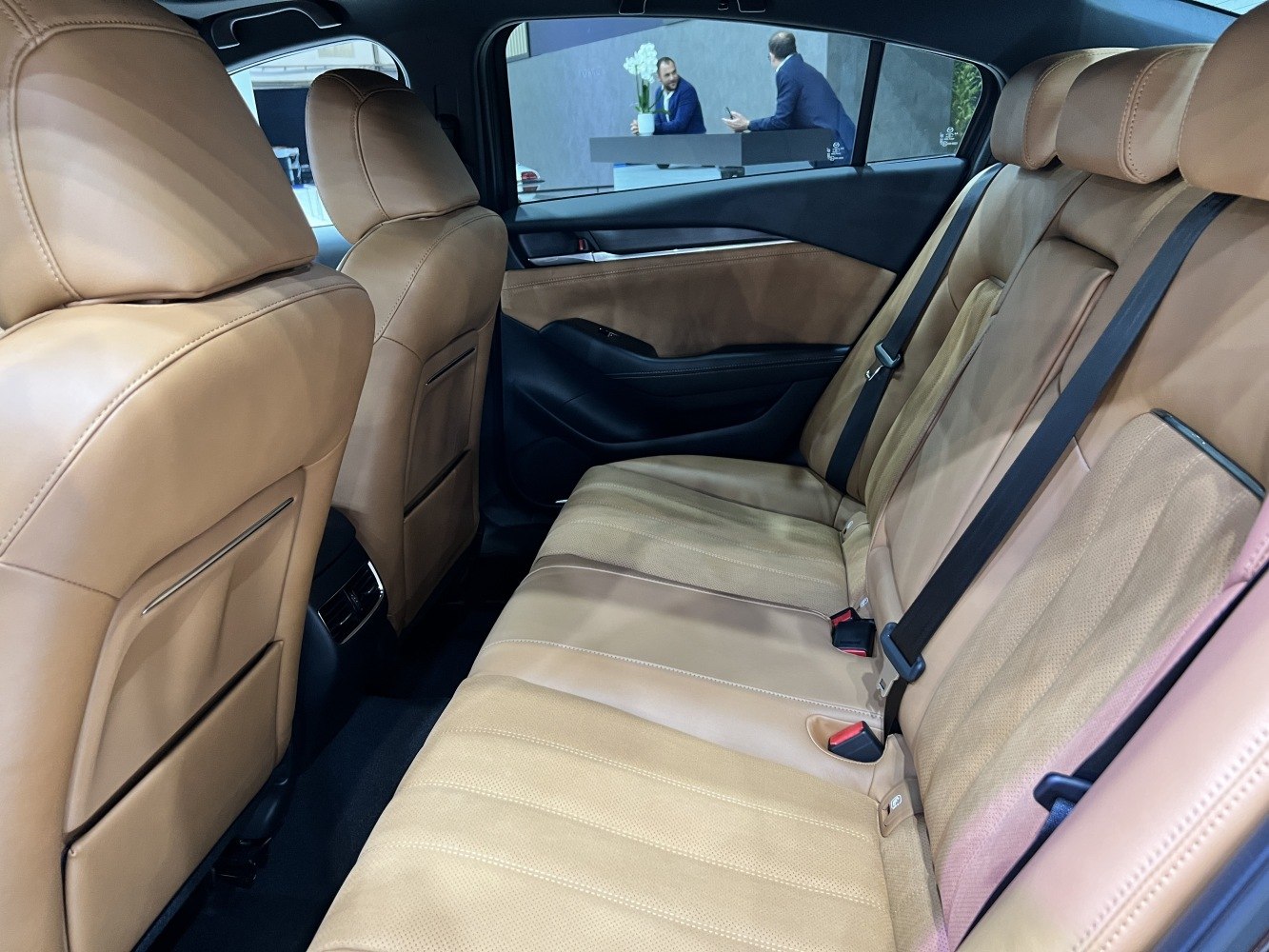 Rear interior with tan leather seats and seat belts