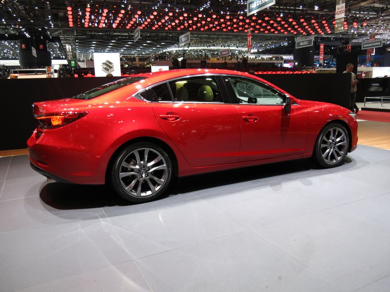 Side profile of a red sedan with alloy wheels and sleek design