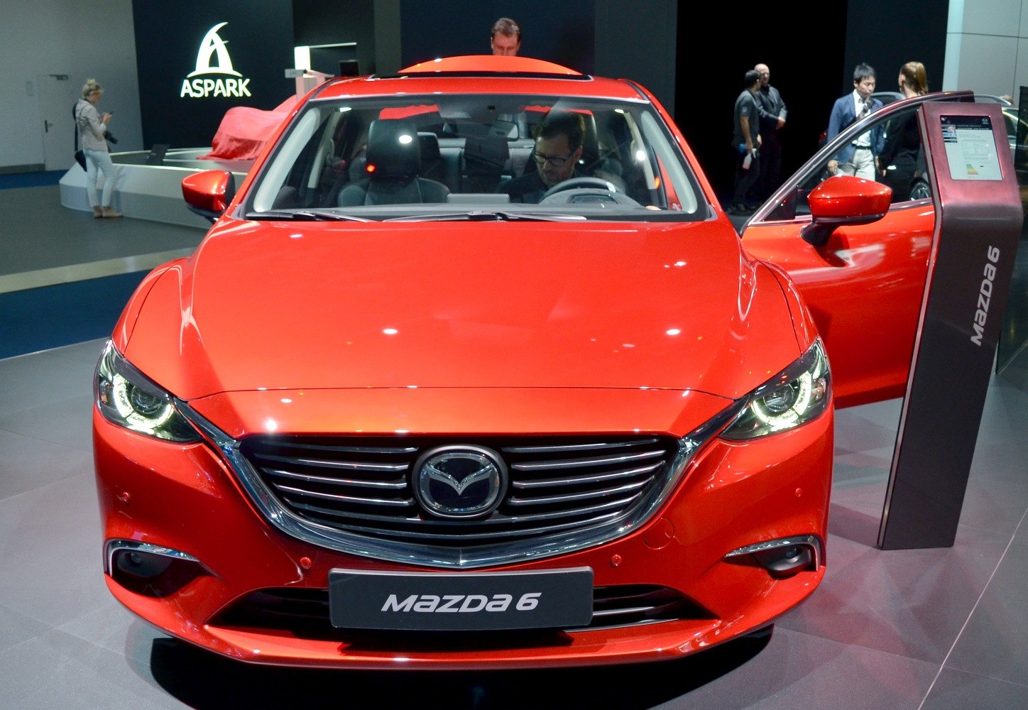 Front view of a red sedan with LED headlights and chrome grille.