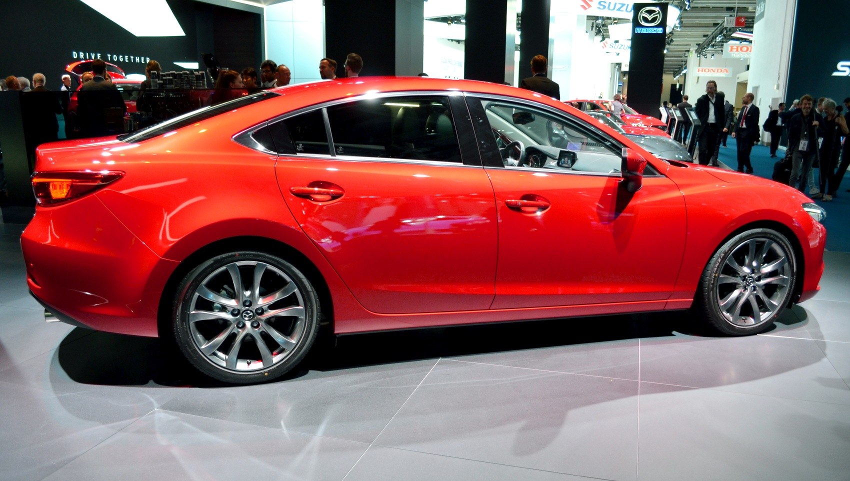 Sleek red sedan side profile with alloy wheels