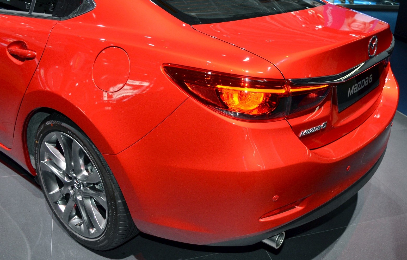 Rear left side with taillight and alloy wheel of red sedan