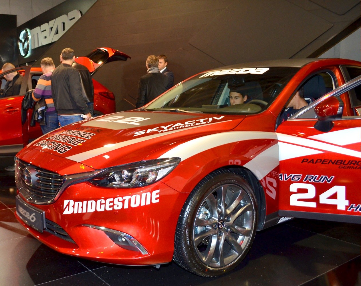 Red Mazda sedan racing edition with aggressive front and Bridgestone branding