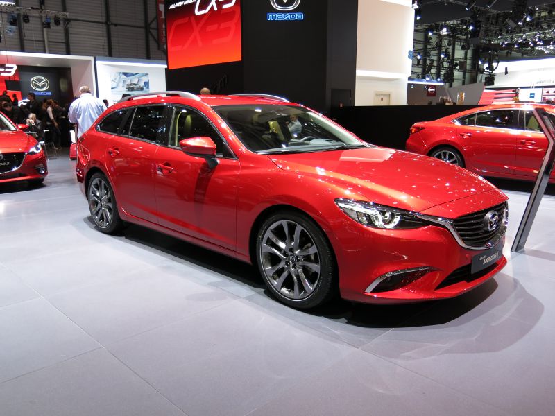 Sleek red five-door station wagon with sporty alloy wheels and modern design.