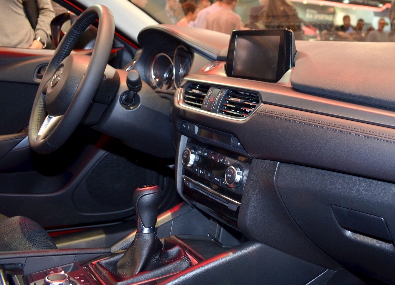 Car interior with dashboard, touchscreen, steering wheel, and gear shift