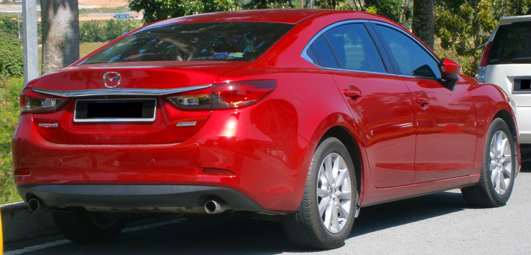 Rear view of sedan with sleek tail lights and dual exhausts