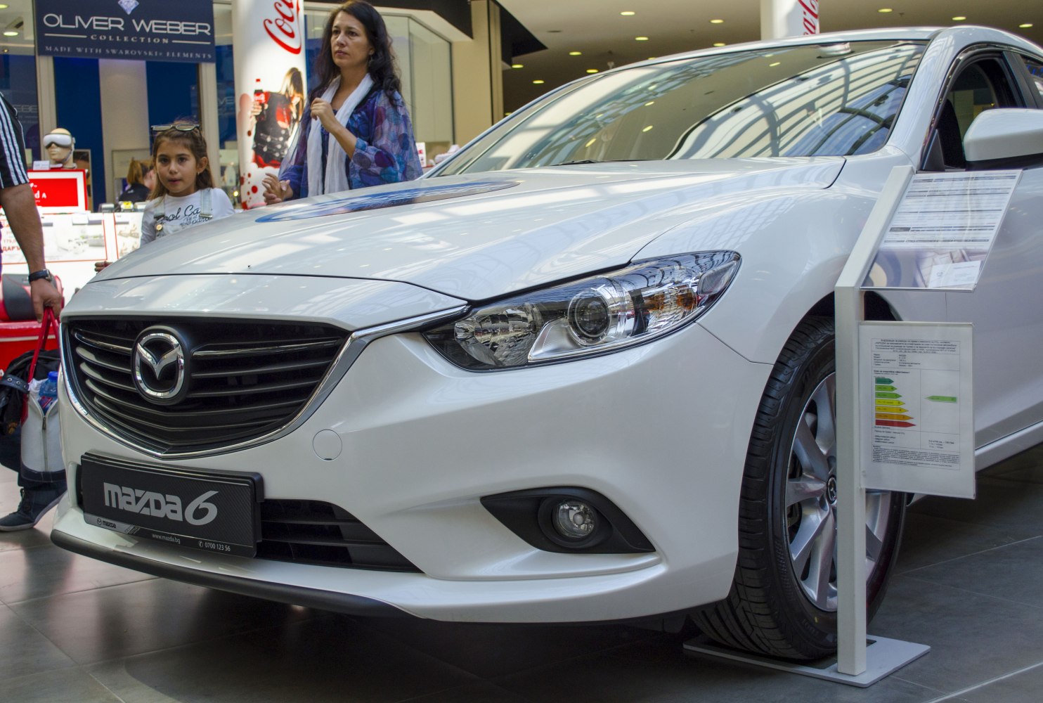 Close-up of sedan front grille, headlight, and wheel with aerodynamic styling