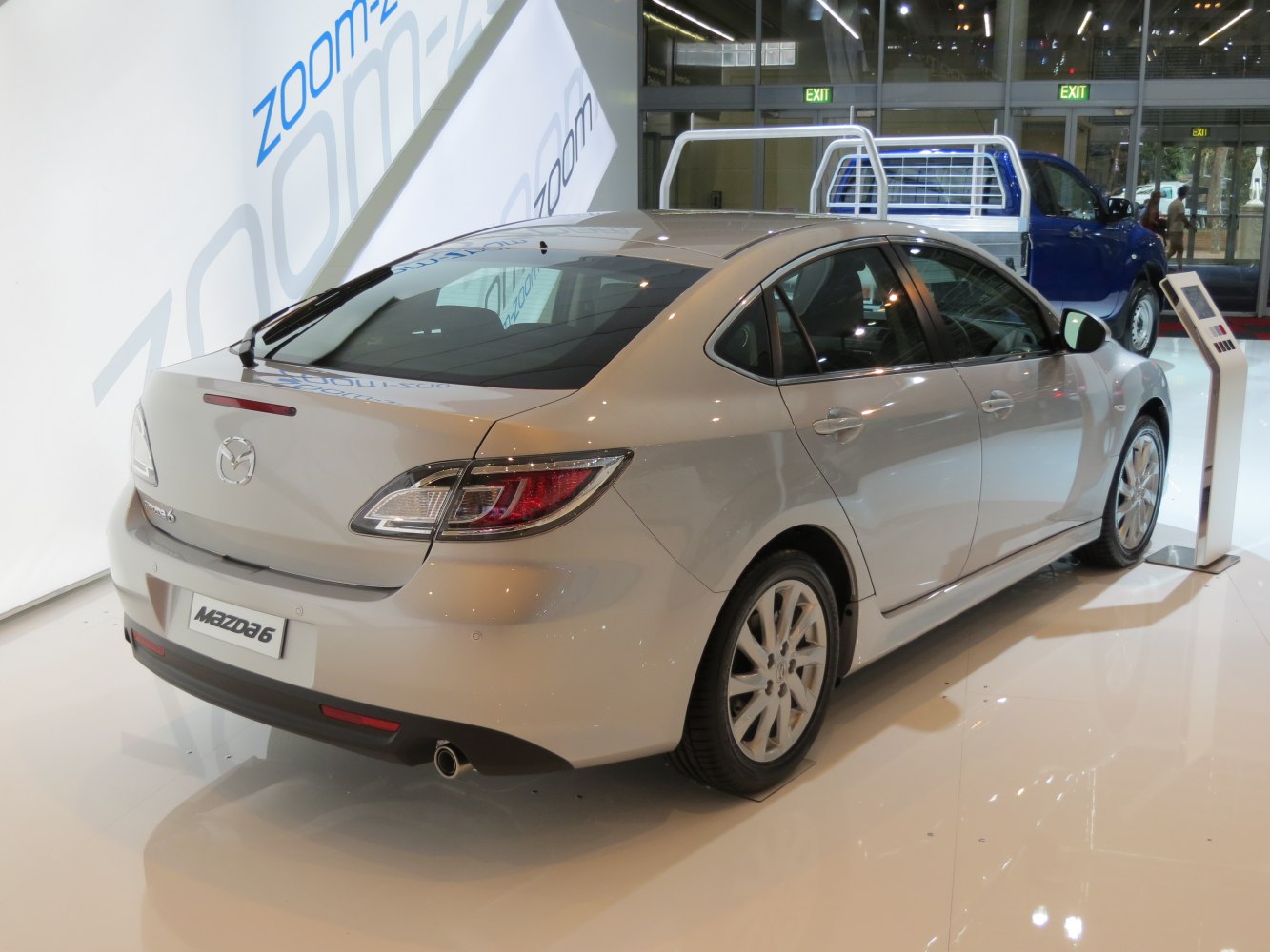 Rear view of a silver sedan with distinct taillights and dual exhaust.