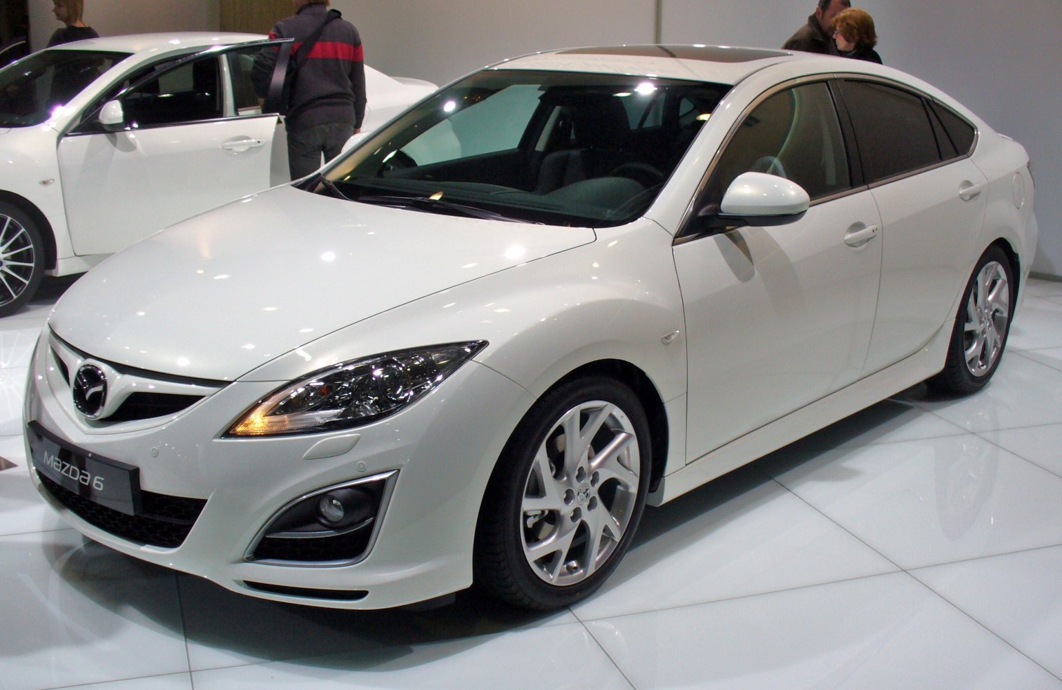 Front side view of white hatchback with alloy wheels