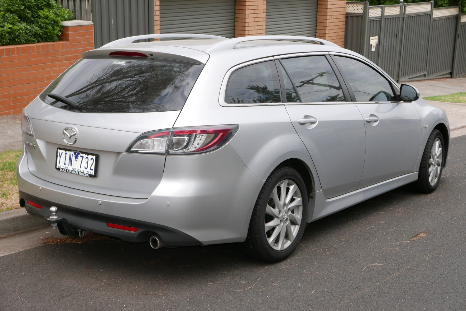 Rear view of silver estate car with roof rails and tow hitch