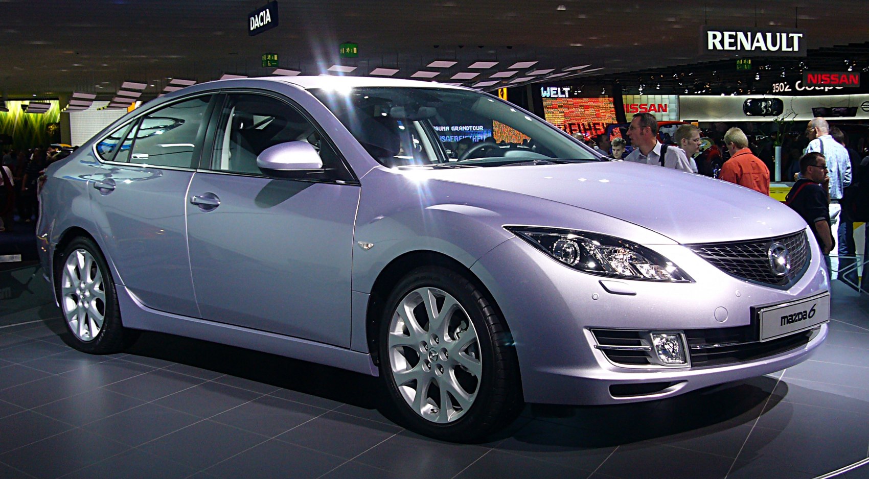 Front side view of sleek hatchback with alloy wheels and distinctive headlights.