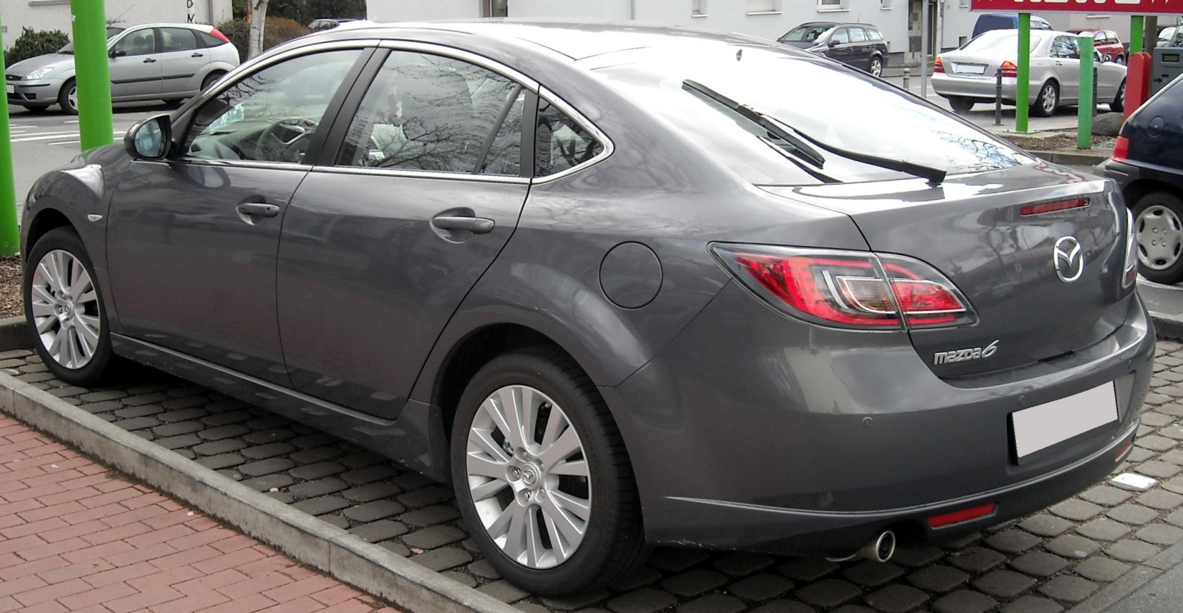 Rear side view of gray hatchback with alloy wheels and distinctive taillights