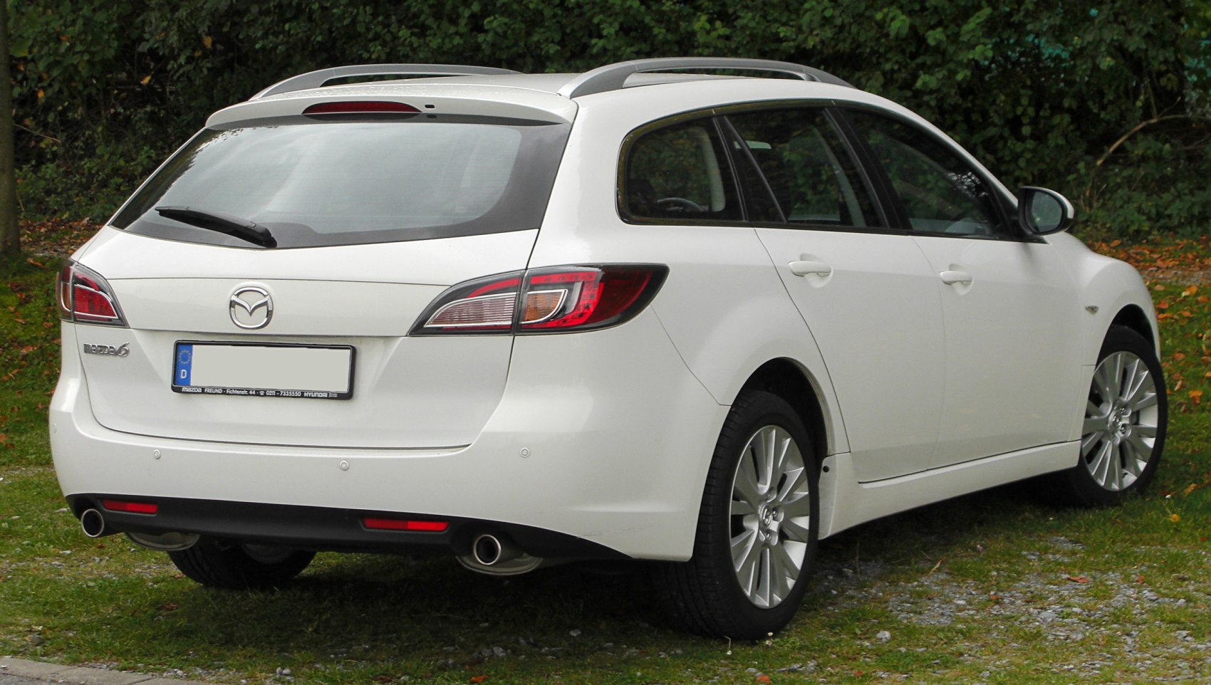 Rear view of wagon with dual exhaust, roof rails, and distinct taillights