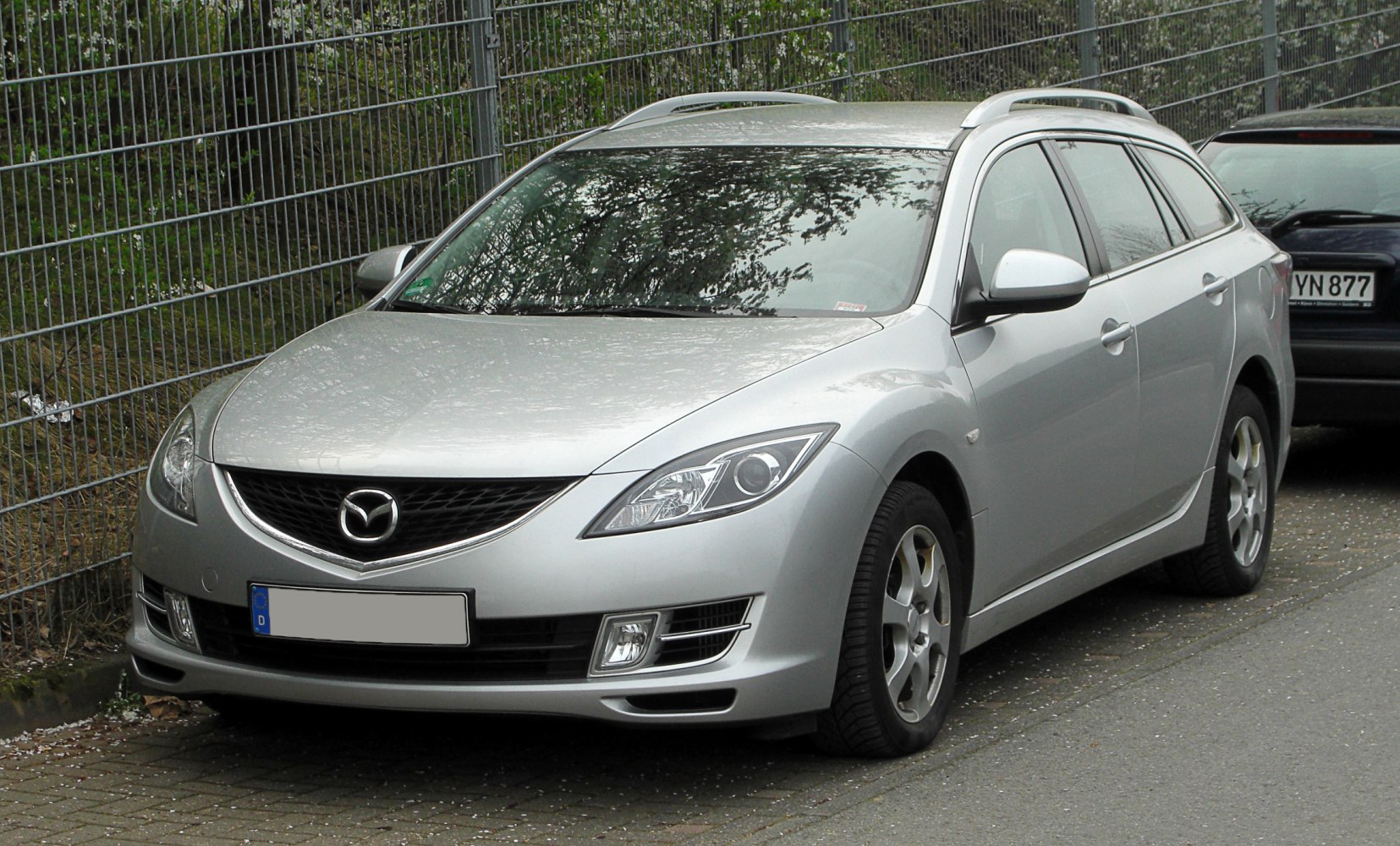 Silver station wagon with sleek headlights and roof rails