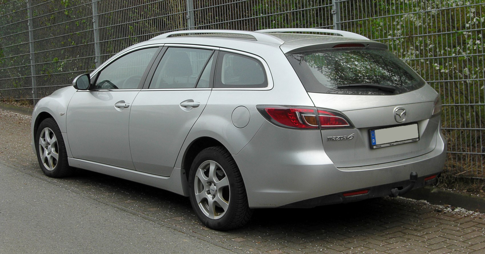Rear side view of an estate with roof rails and alloy wheels