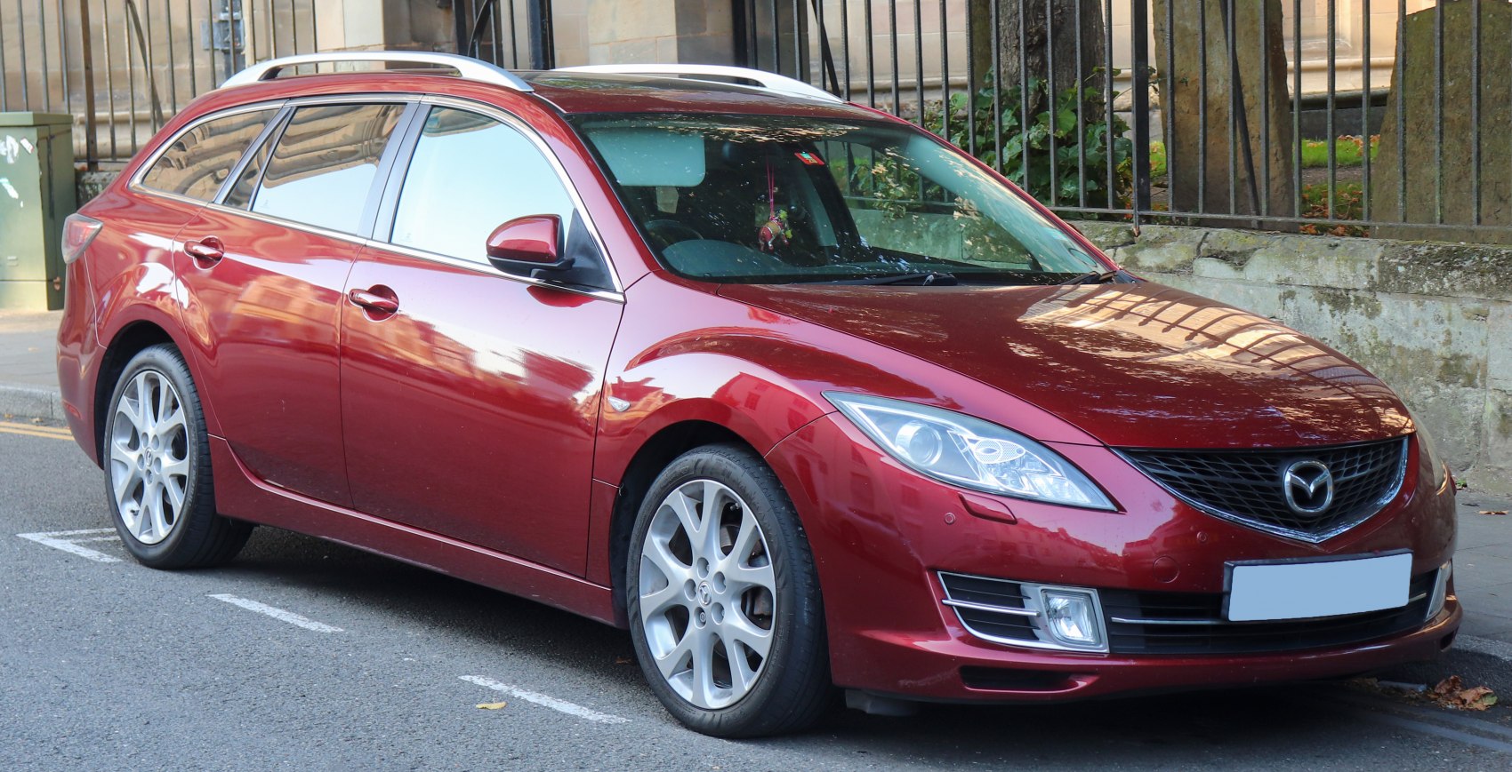Red wagon with sleek front and side profile, roof rails, alloy wheels