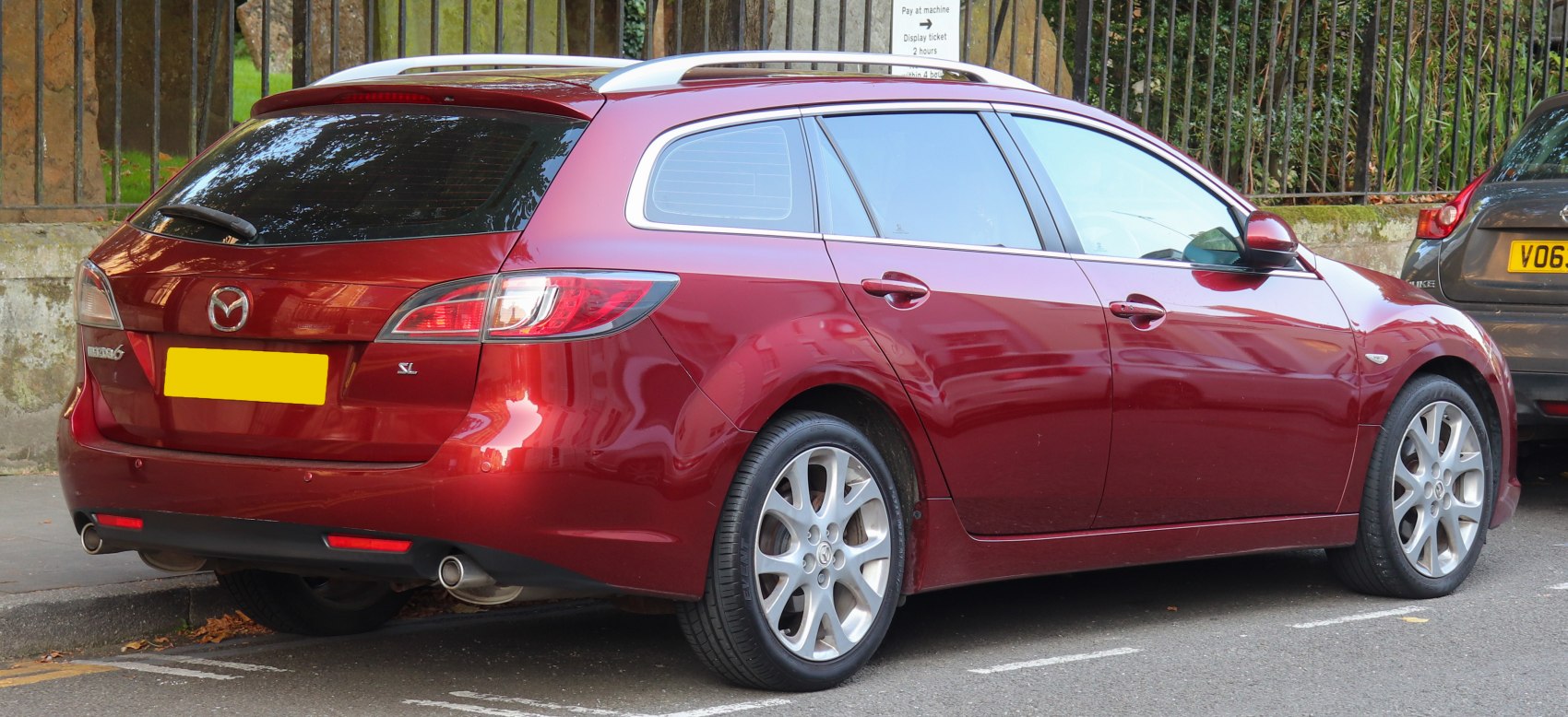 Red estate car rear side with dual exhausts and roof rails