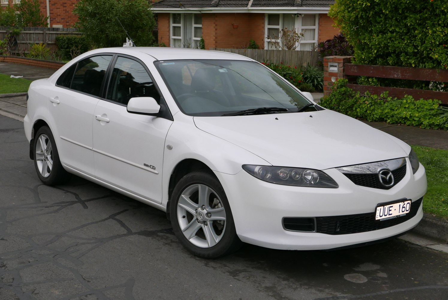 Distinctive sleek headlights and sporty alloy wheels on a white hatchback.