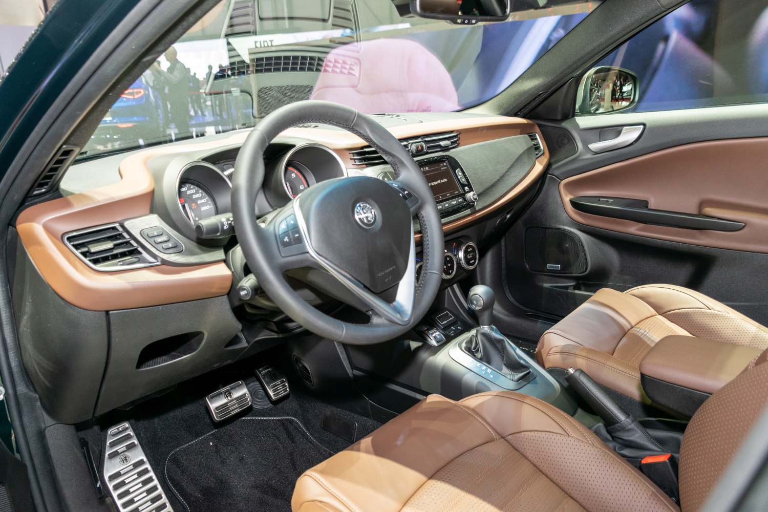 Interior with dashboard, steering wheel, and brown leather seats
