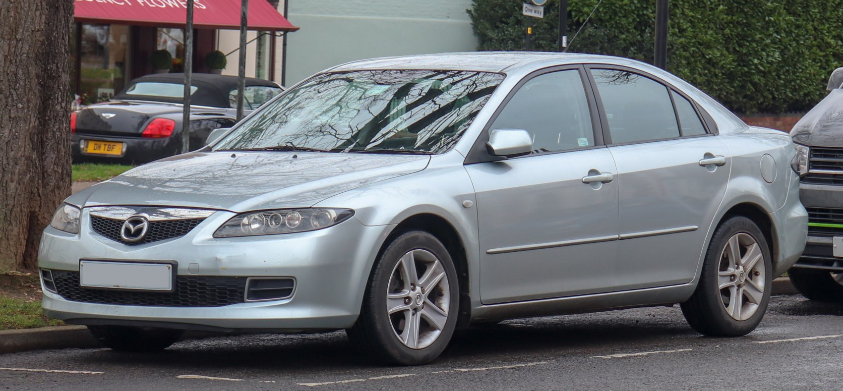 Silver mid-size sedan front side view with alloy wheels