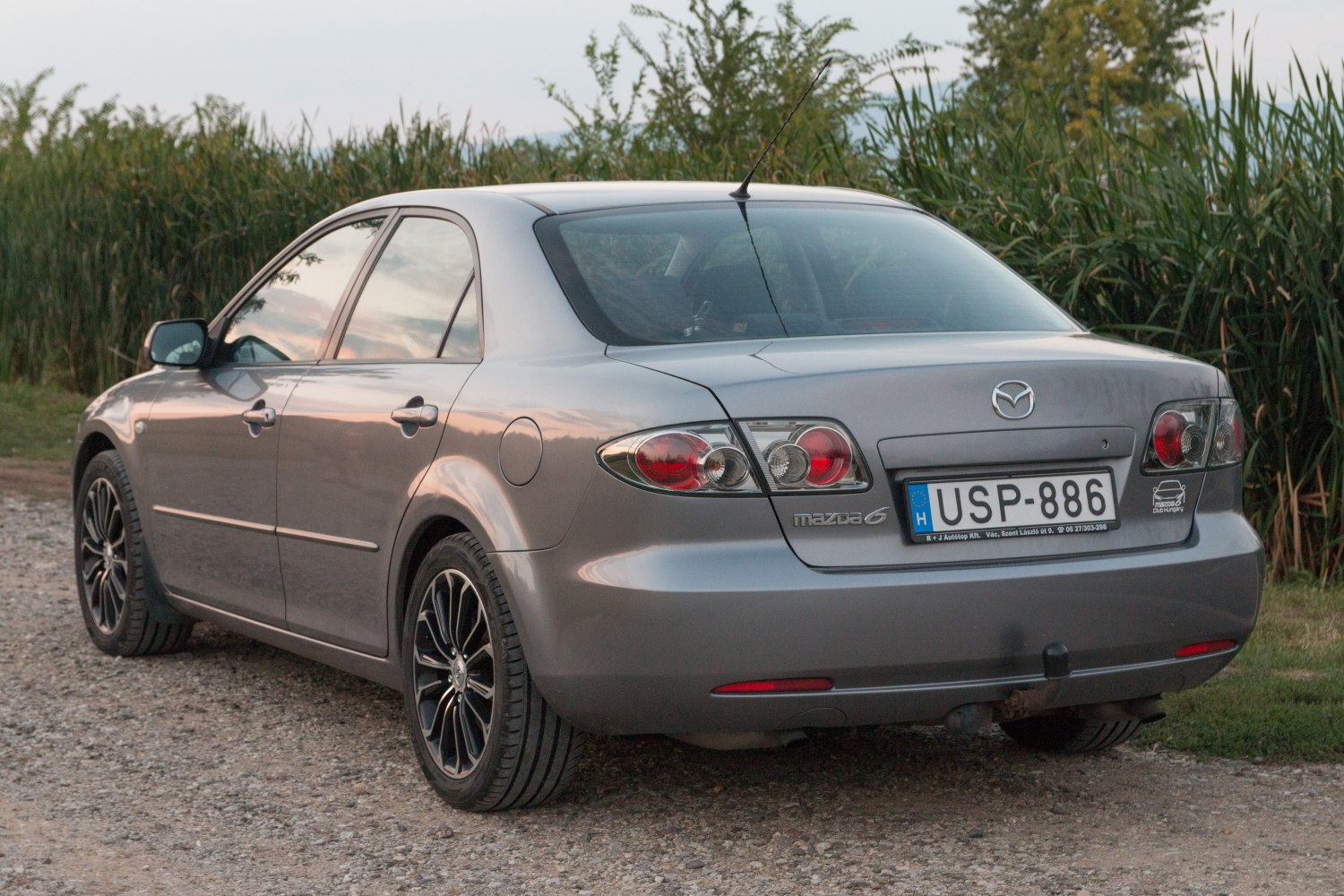 Rear view of sedan with distinctive tail lights and black alloy wheels