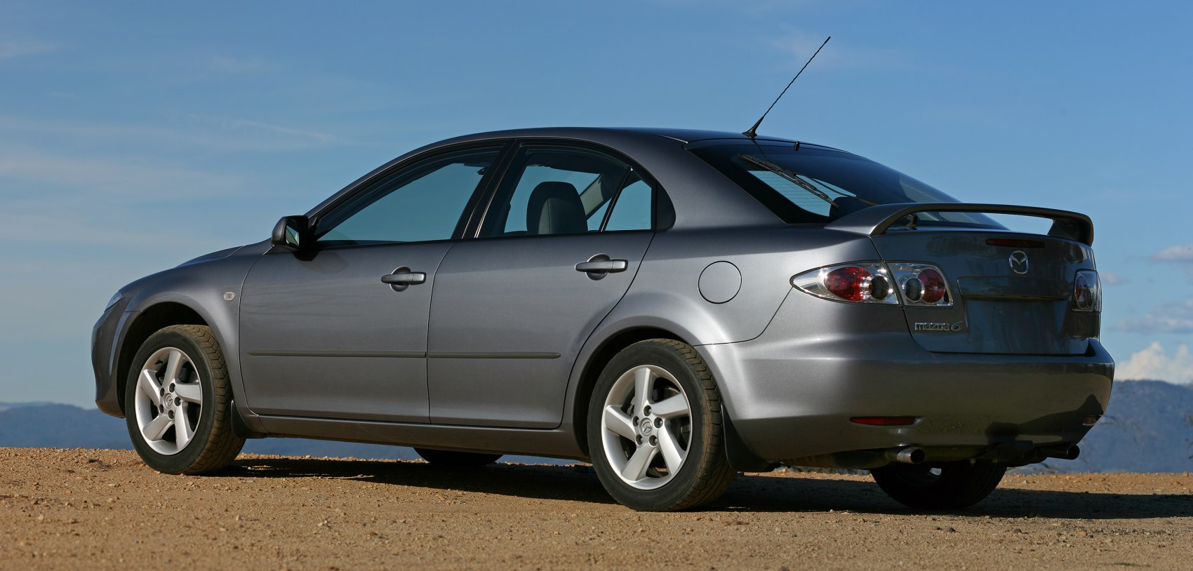 Rear side view of hatchback with alloy wheels and roof spoiler