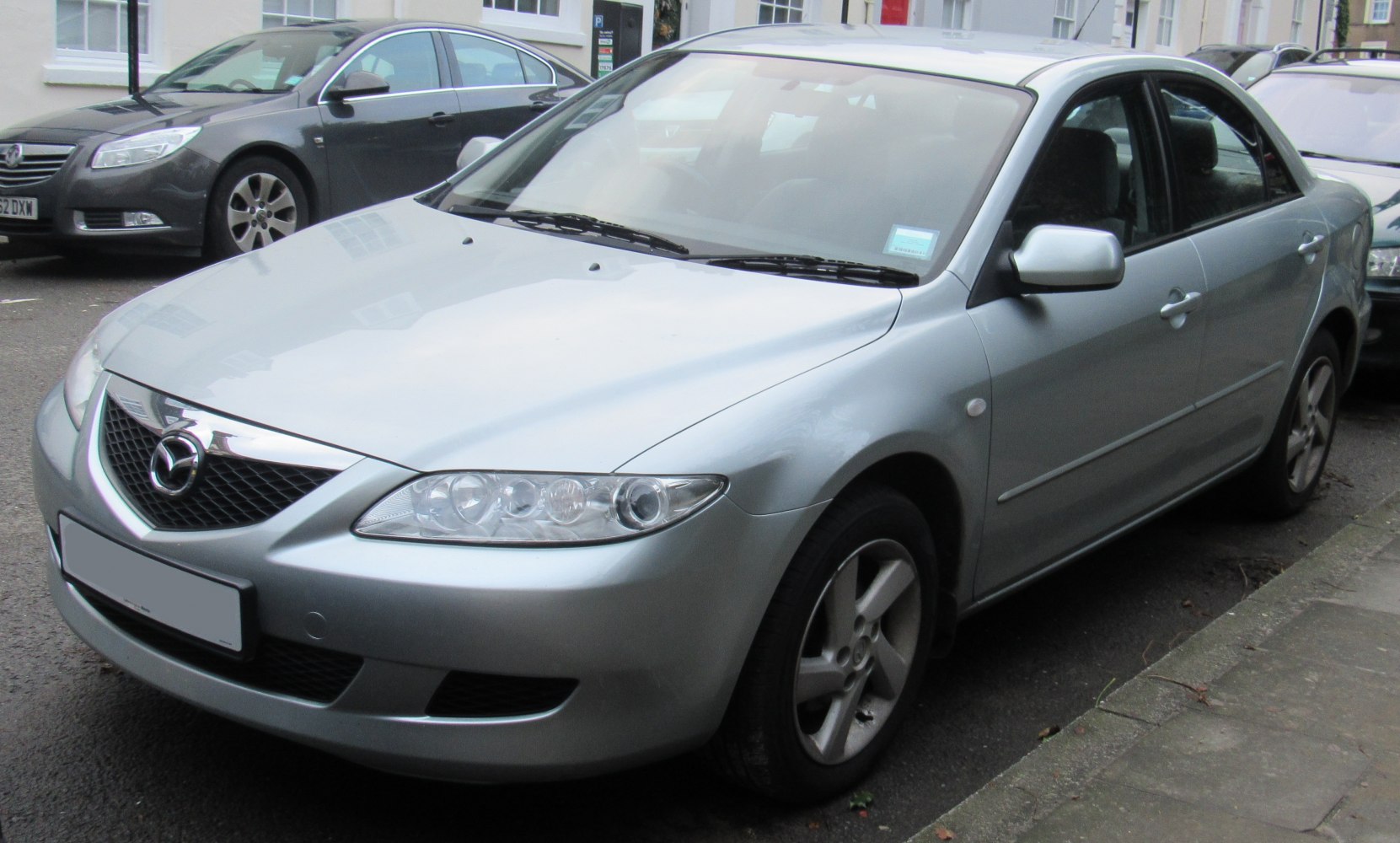 Silver sedan front and side with multi-lens headlights and prominent grille