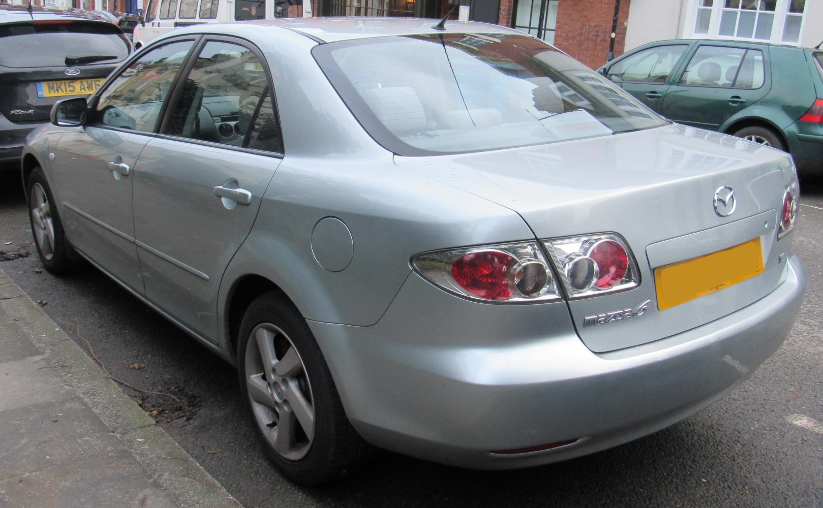 Silver mid-2000s sedan rear view with unique tail lights and alloy wheels