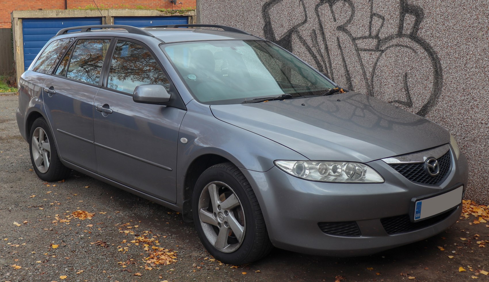 Front and side view of gray wagon with alloy wheels and distinctive headlights