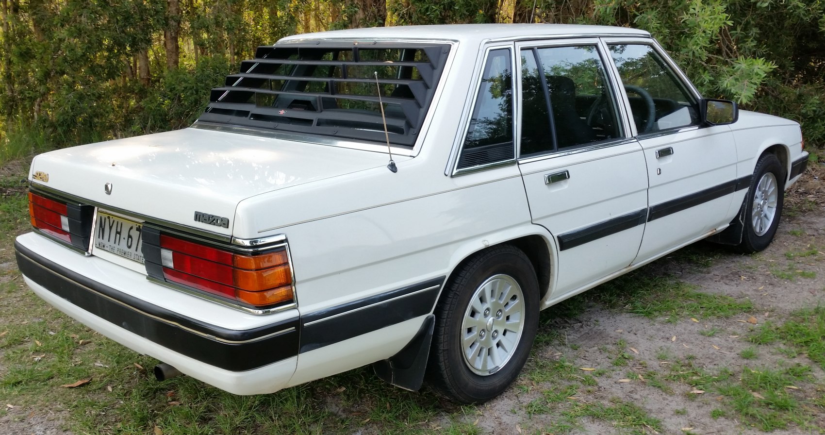 Rear view with distinctive window louvers and classic tail lights.
