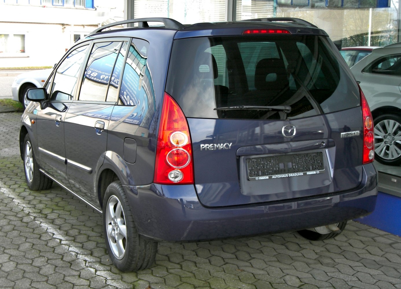 Rear and side view of a compact MPV with vertical taillights and roof rails