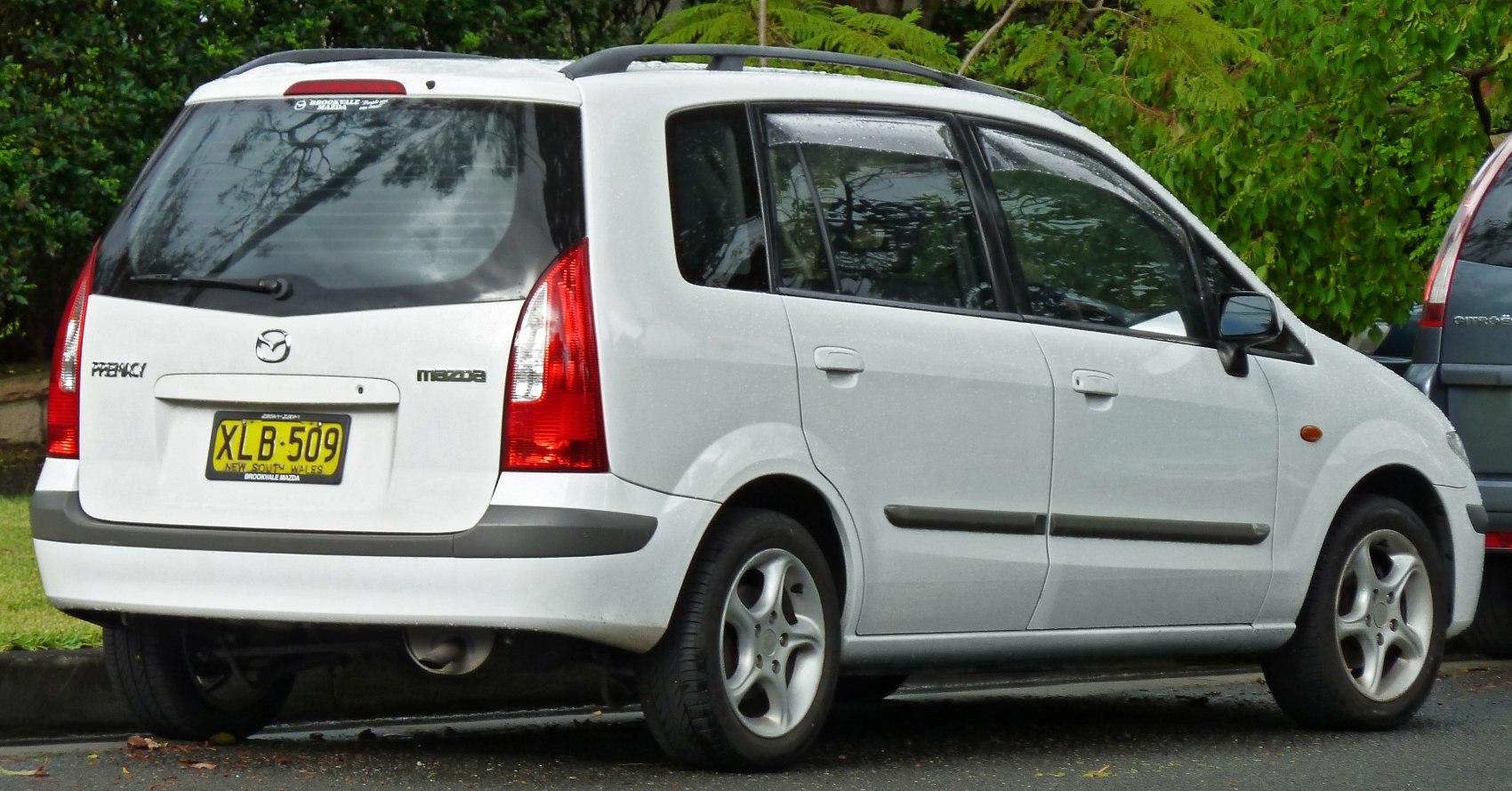 Rear and side view of compact MPV with prominent tail lights and rear window