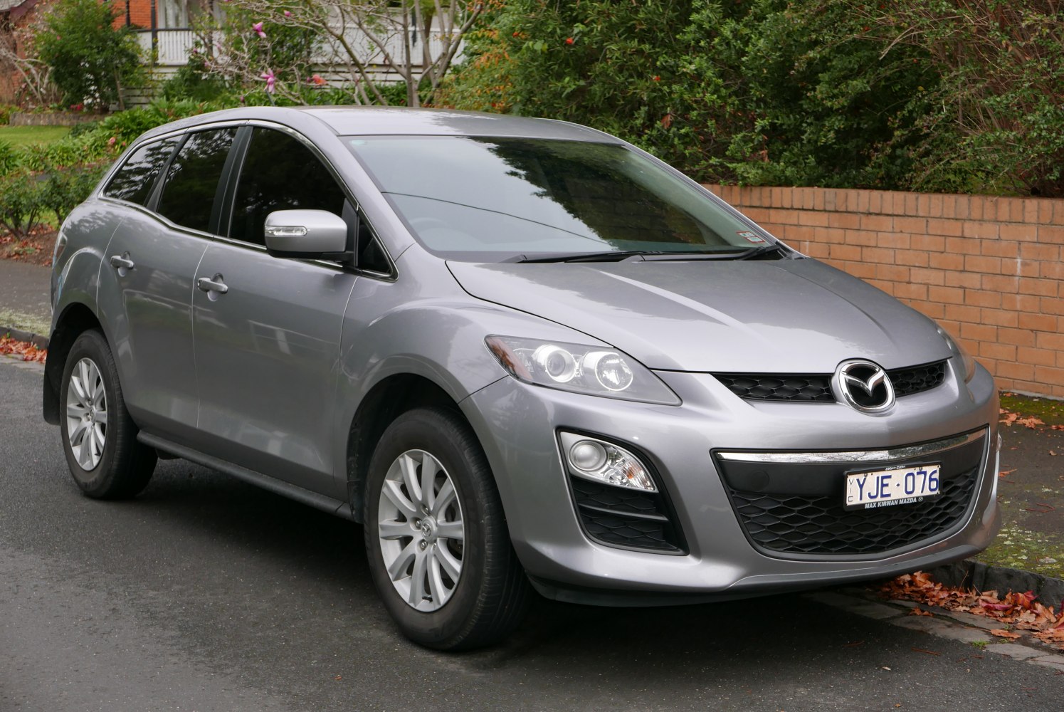 Silver midsize SUV front side view with prominent headlights and grille