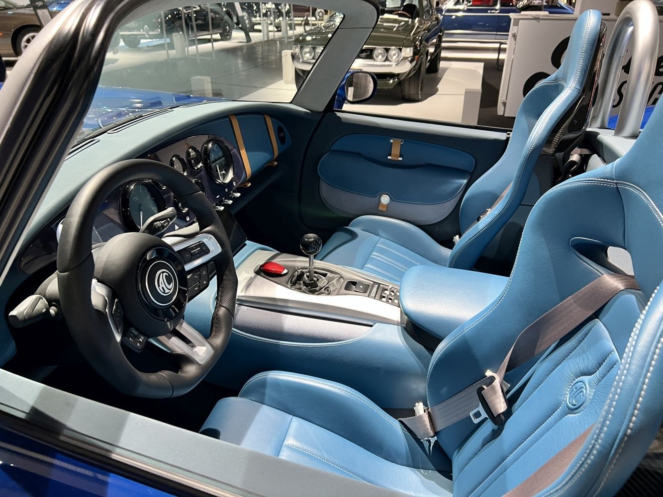 Blue leather sports seats with manual gear shifter and classic gauges