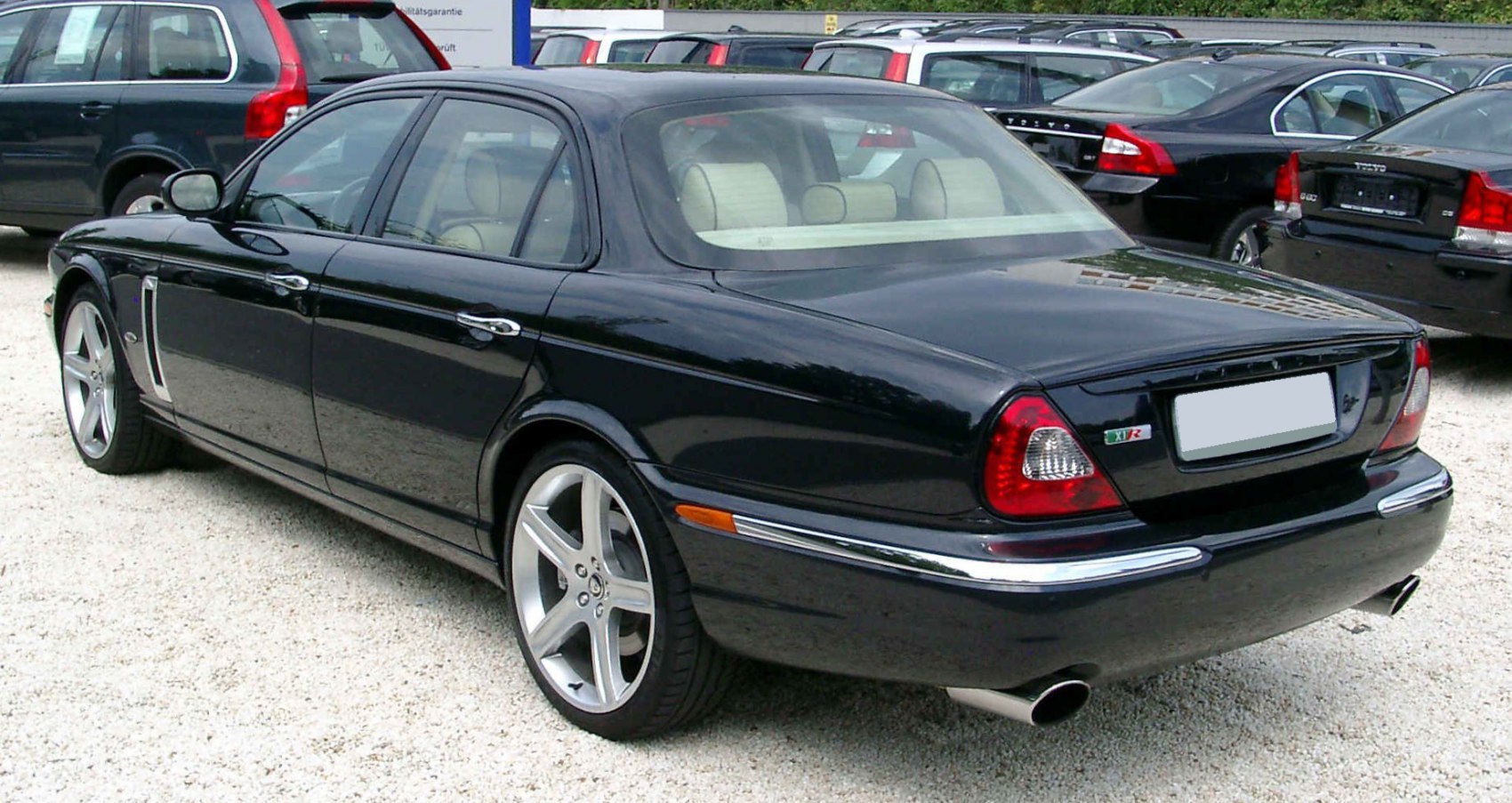 Rear view of black luxury sedan with distinctive taillights and dual exhaust pipes
