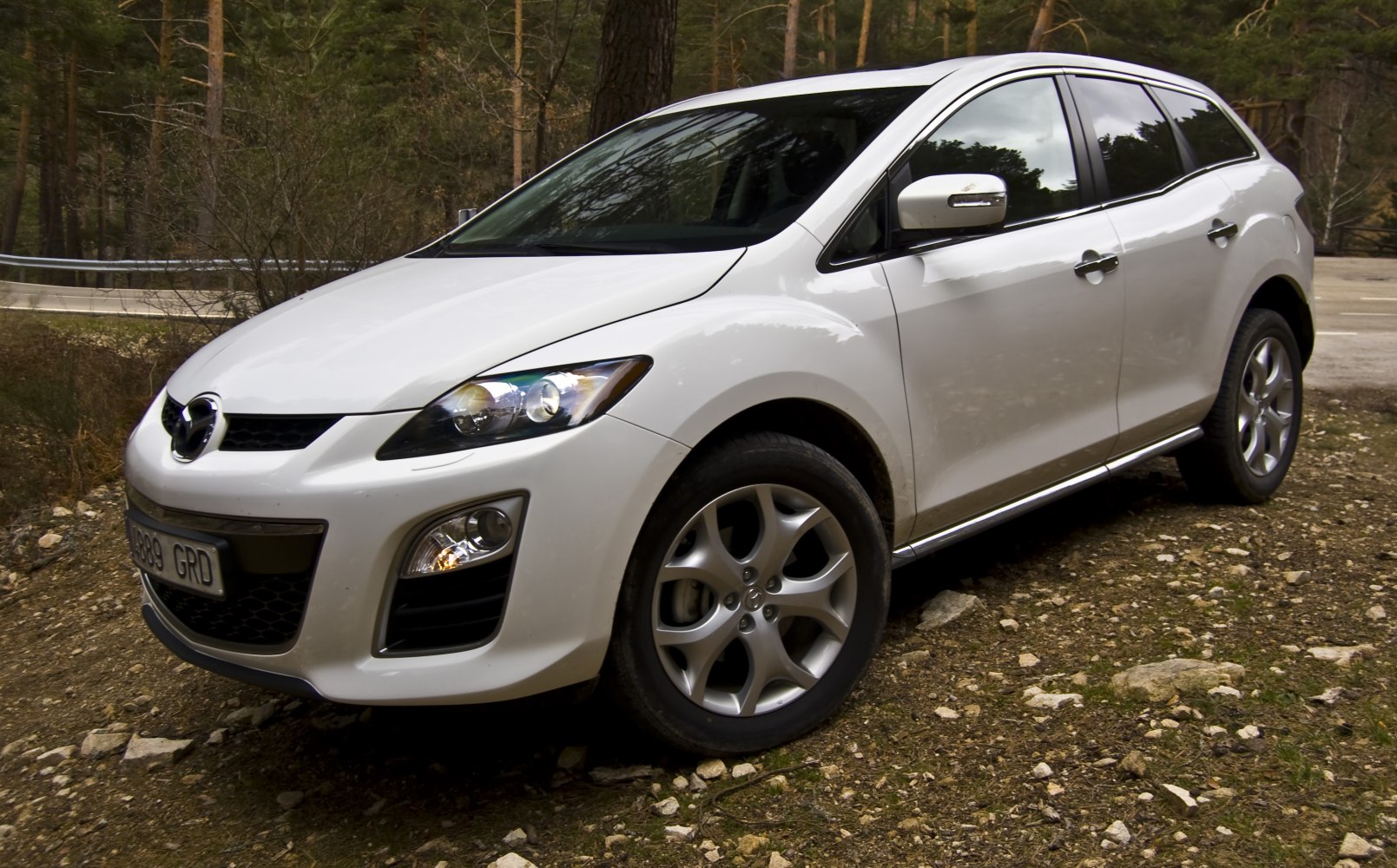 Front 3-4 view of white SUV with distinct headlights and alloy wheels