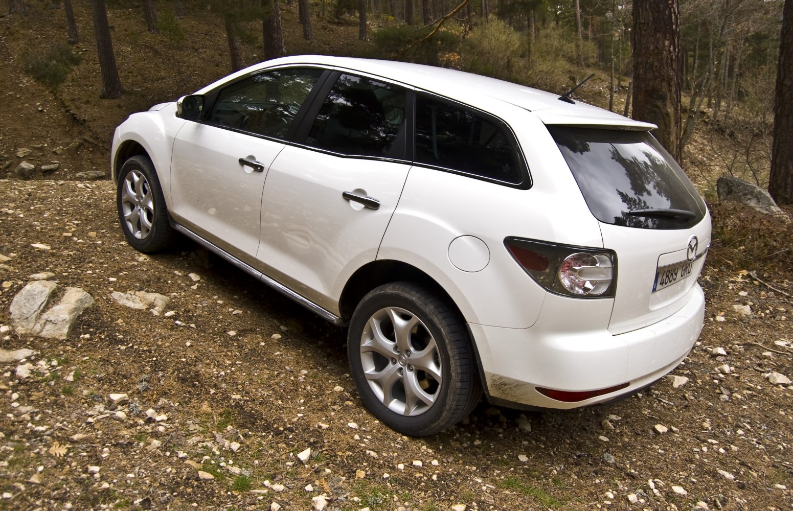 Rear and side view of SUV on rocky off-road ground