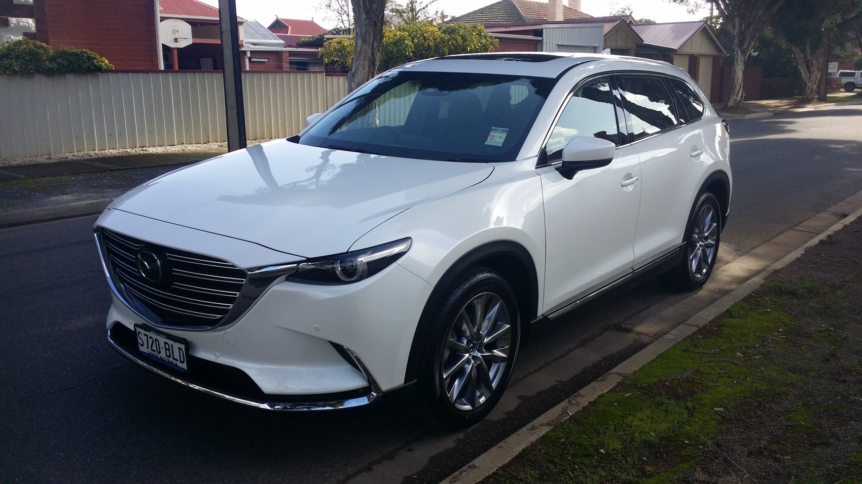 Sleek front grille and headlight design with side profile of white SUV